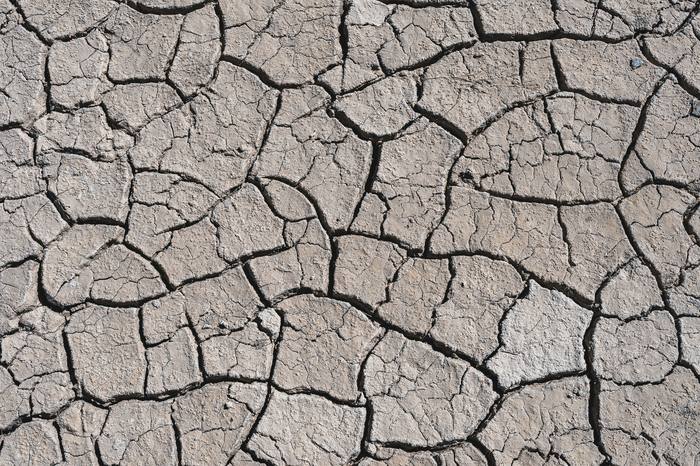Cracked soil representing moisture swings and ground movement